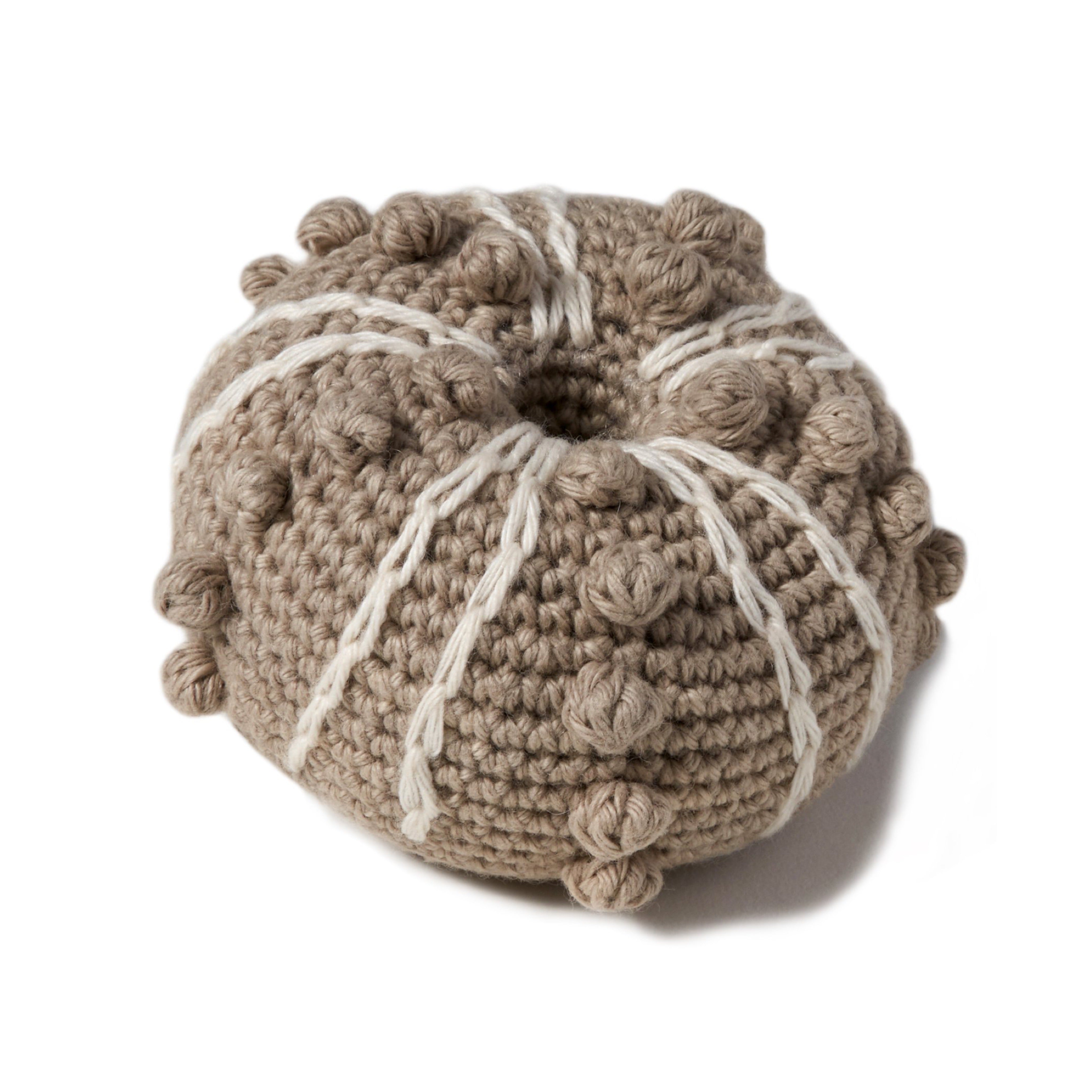natural organic soft toy in the shape of a sea urchin with a rattle inside and at 3 1/2" in diameter.. 100% organic cotton hand crochet knit.
