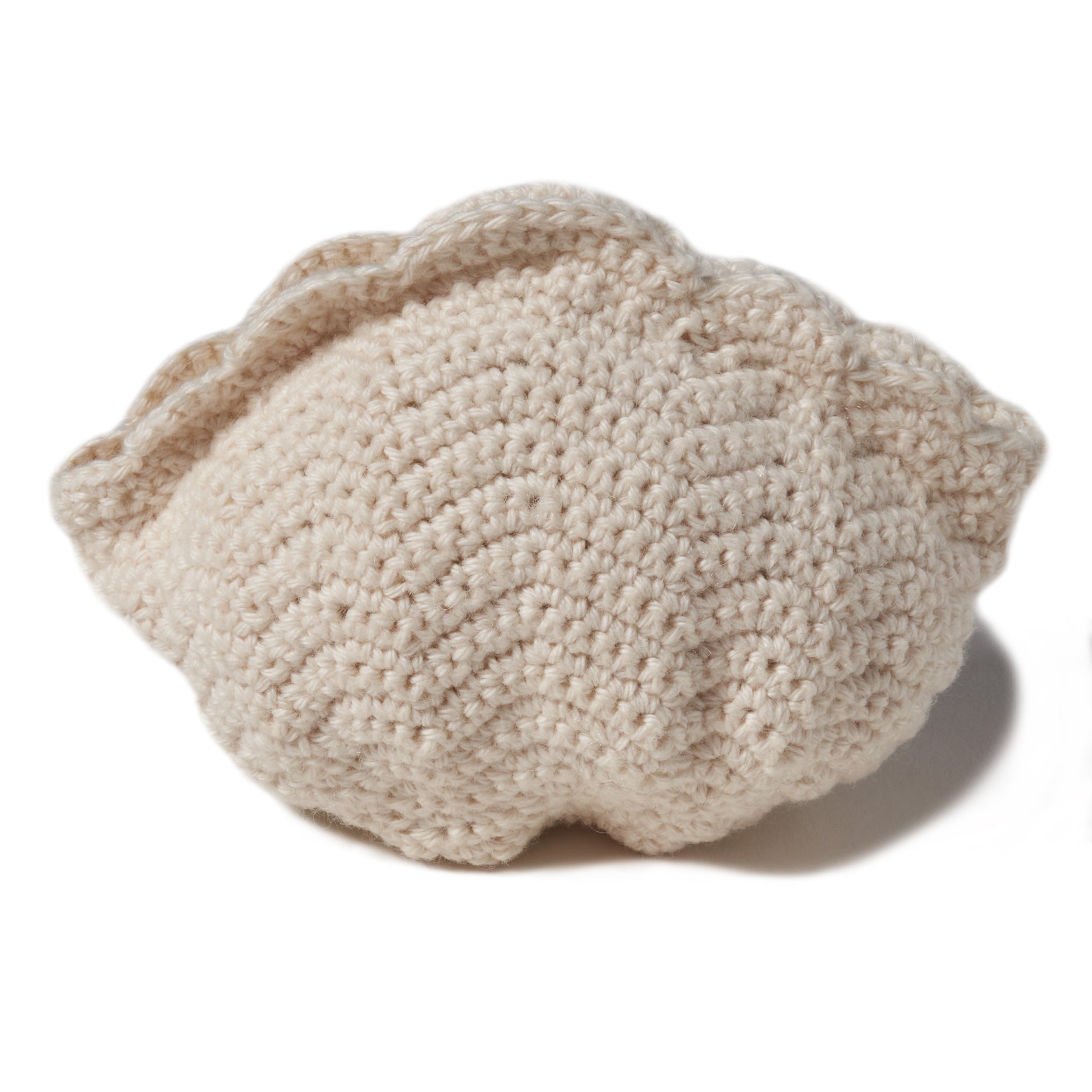 natural organic soft toy in the shape of a sea scallop shell with a rattle inside and at 5" in width.  100% organic cotton hand crochet knit.