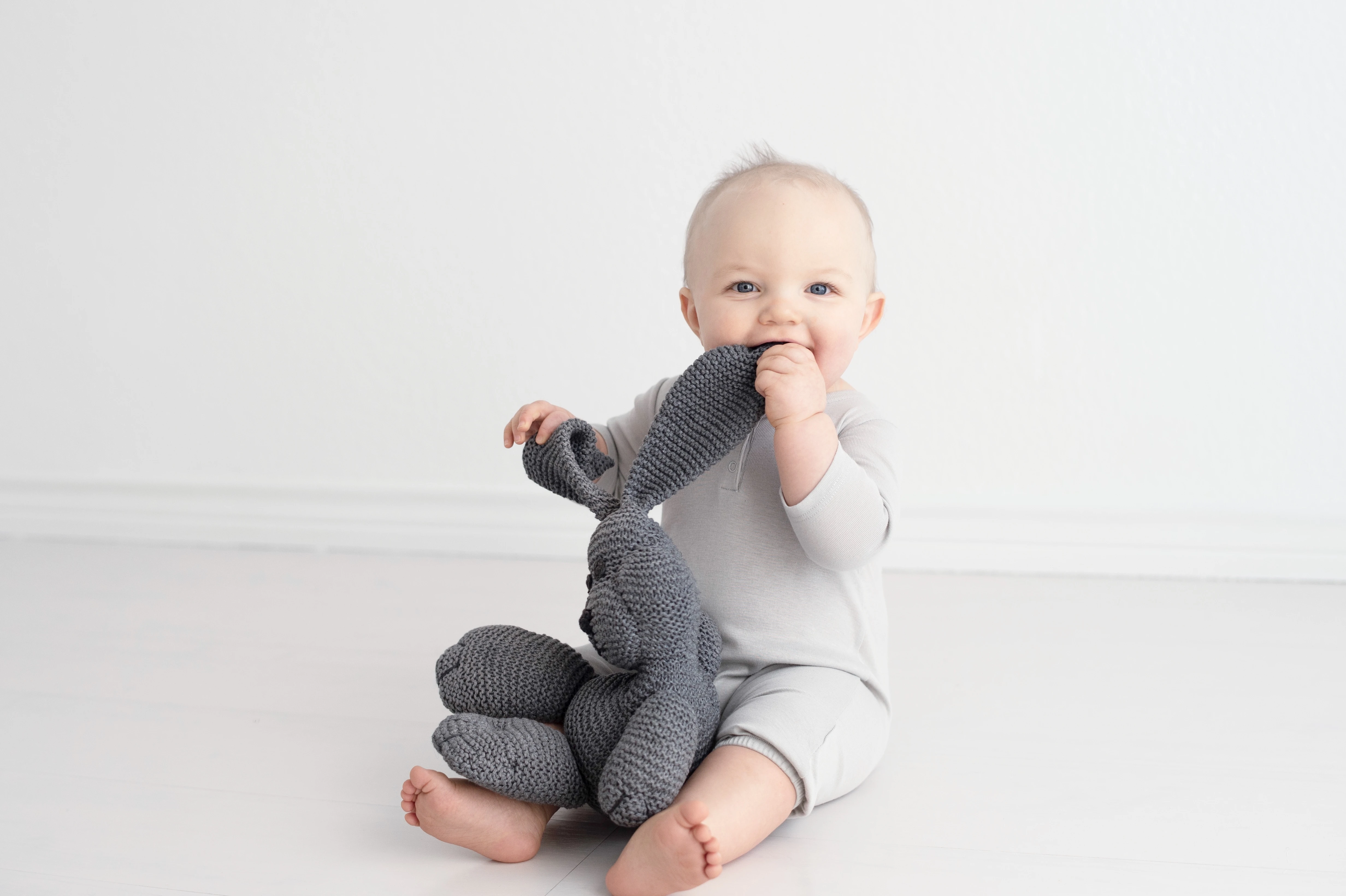 Cool grey long sleeved henley balloon coverall with charcoal color hand knit snuggle bunny organic soft toy